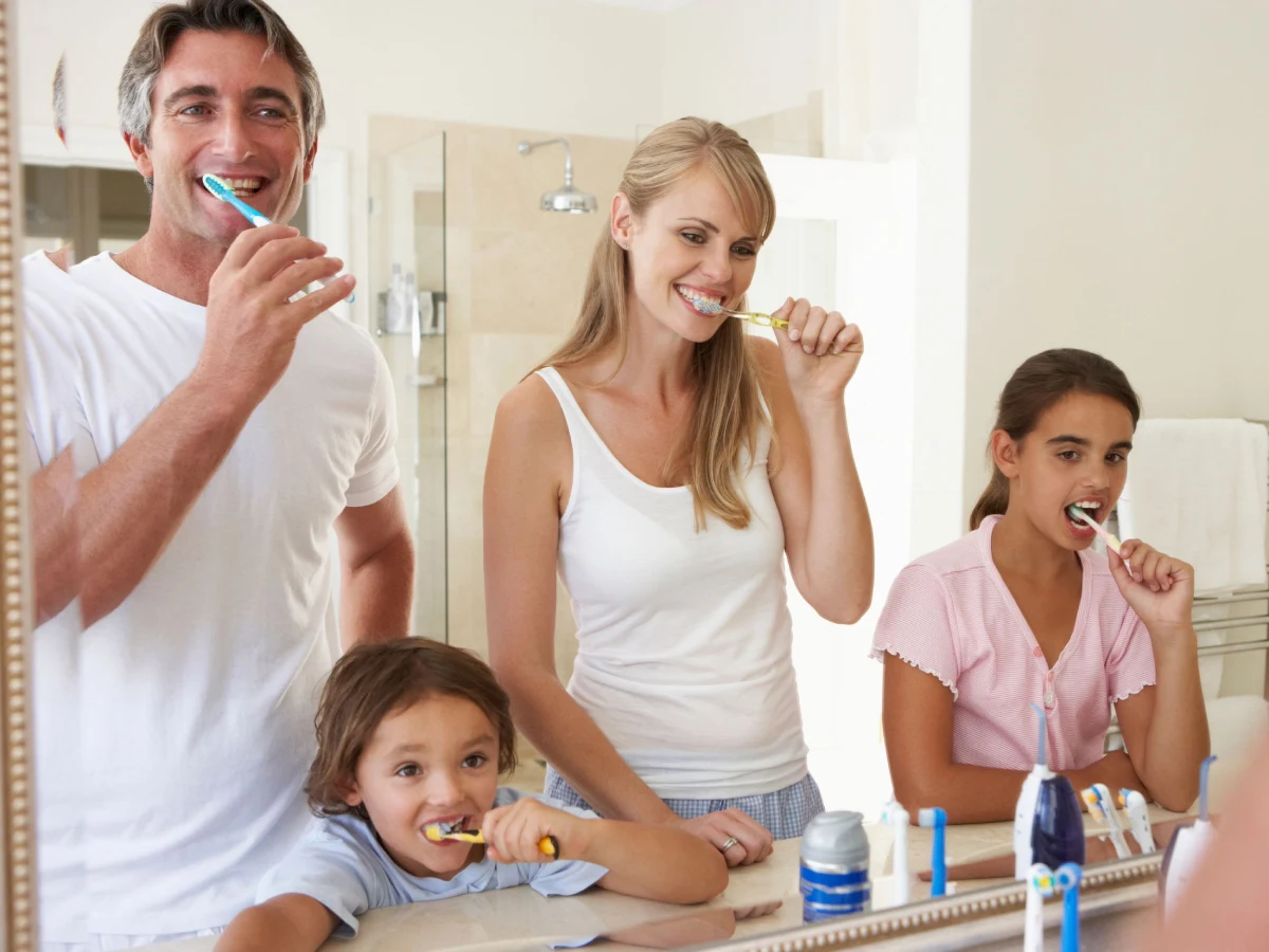 familia cepillándose los dientes frente al espejo